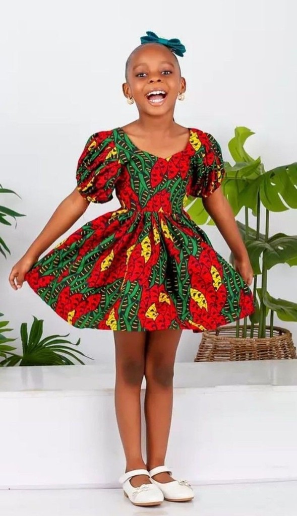 Girl in red and green Ankara dress with puff sleeves