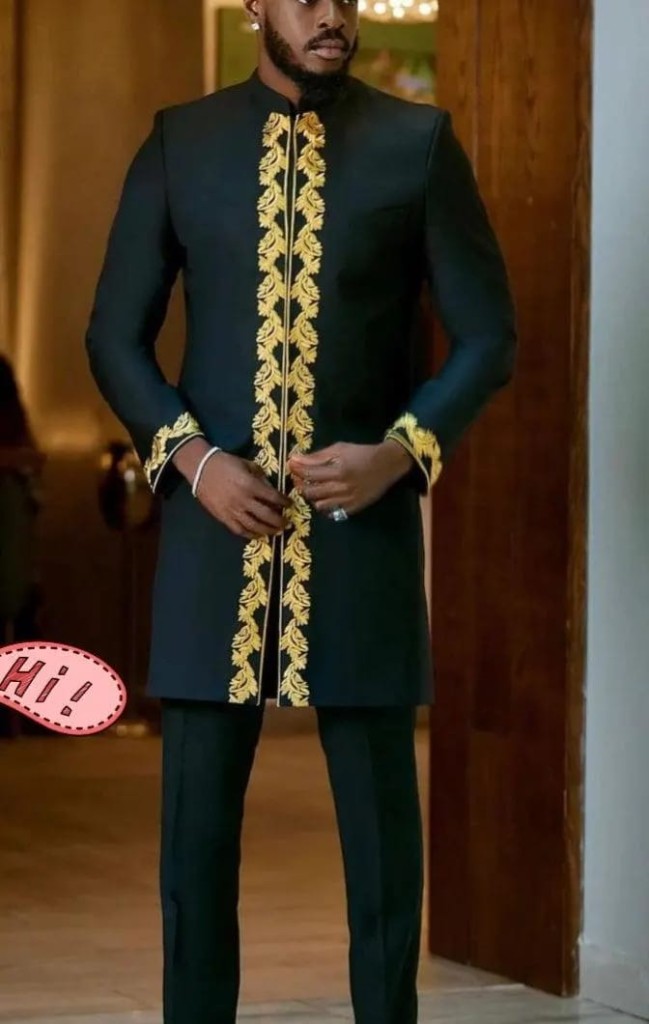 Man in black formal tunic with gold embroidery and matching trousers