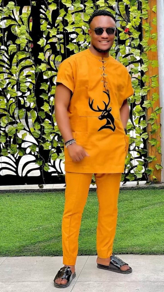 Man in mustard yellow tunic and trousers with deer graphic