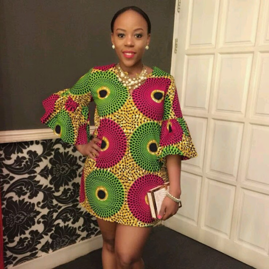 Model in magenta and green circle print Ankara dress with bell sleeves